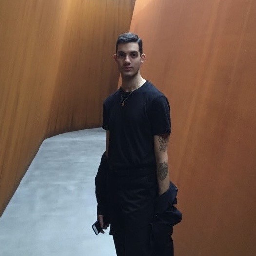 A view of a studio interior with modern decor, featuring large windows that offer a glimpse of lush greenery outside