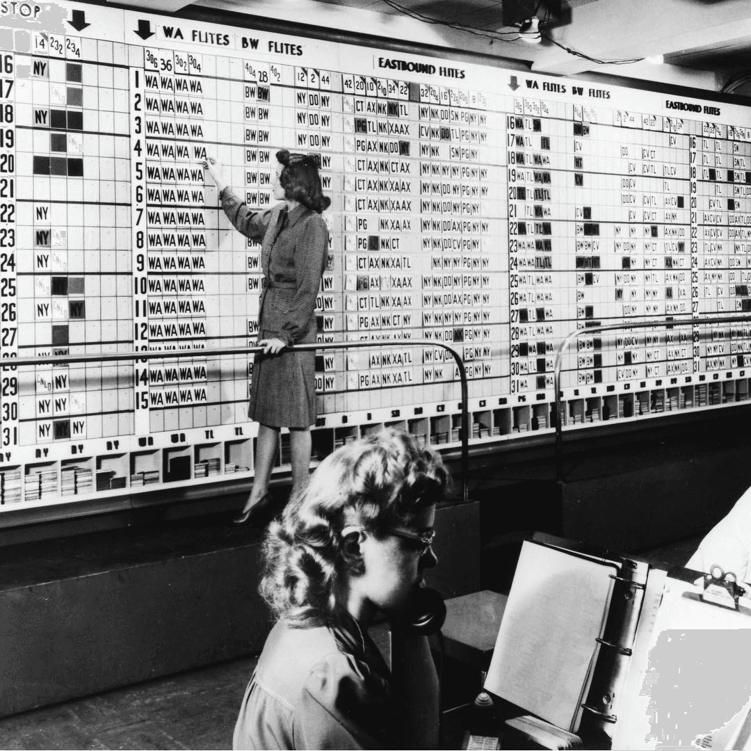 A woman standing in front of a huge analogue planning board