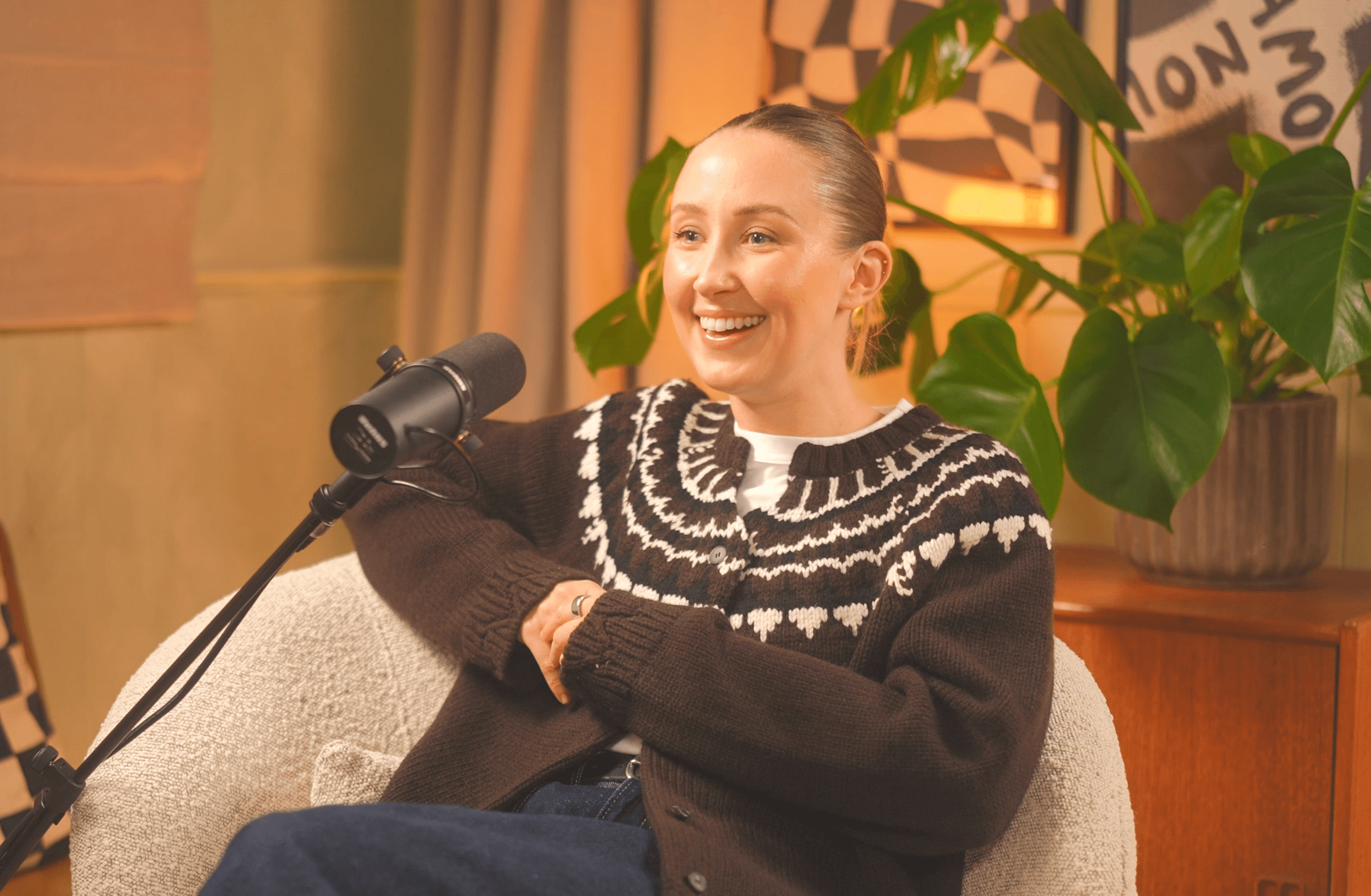 Podcast House_Podcast guest speaking into a professional microphone in a cozy studio recording setup