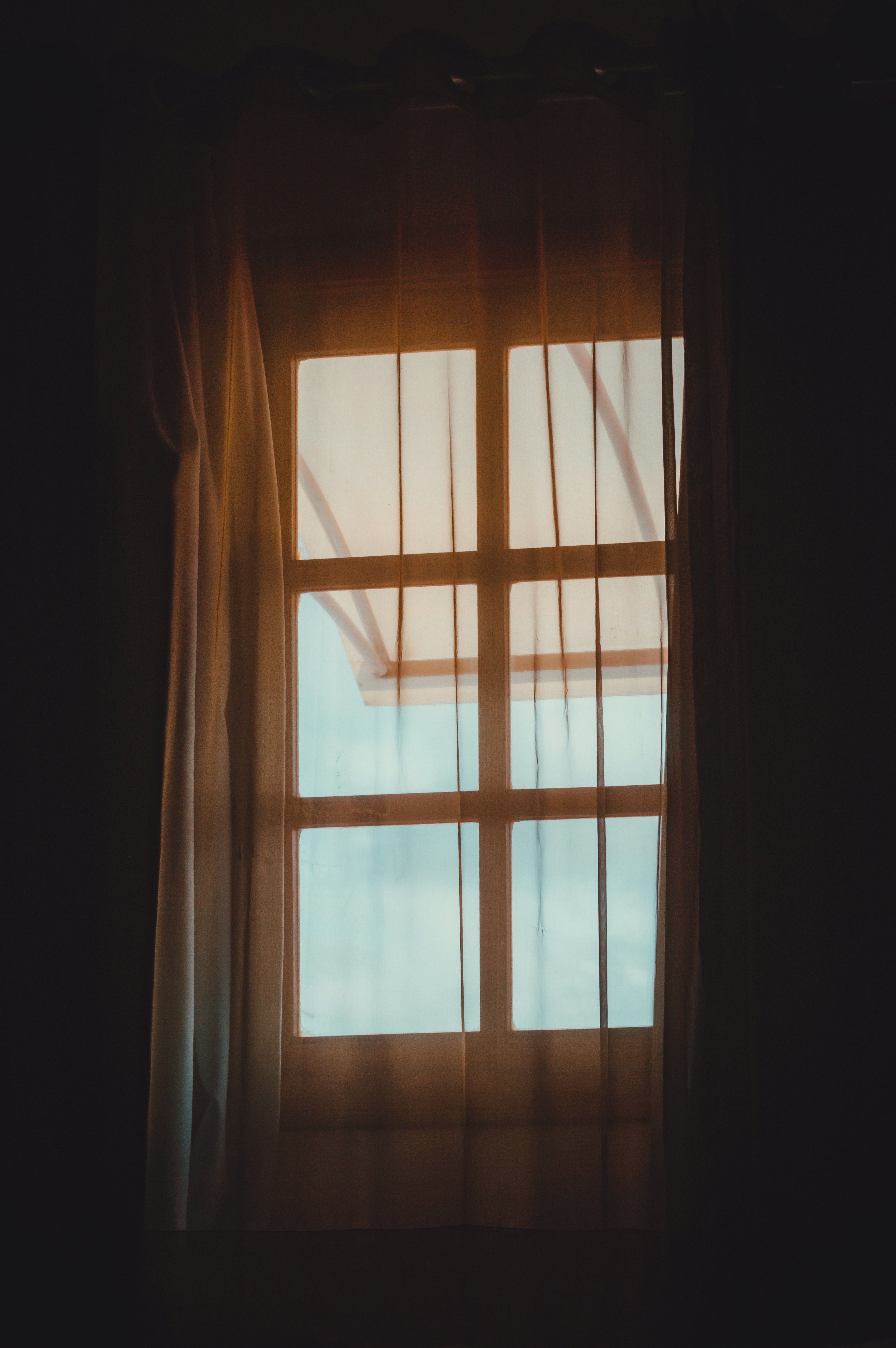 Window with sheer curtains and bright sunlight
