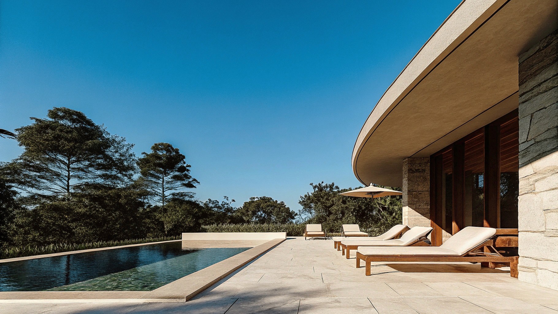 nfinity pool blending into the ocean view, minimalist sun loungers in soft neutral fabric, curved architecture