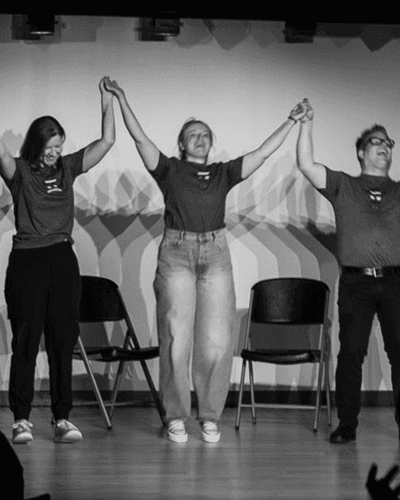 Improv performers laughing and engaging with the audience during a live comedy show at Black Sheep Comedy in Carrboro and Chapel Hill, NC