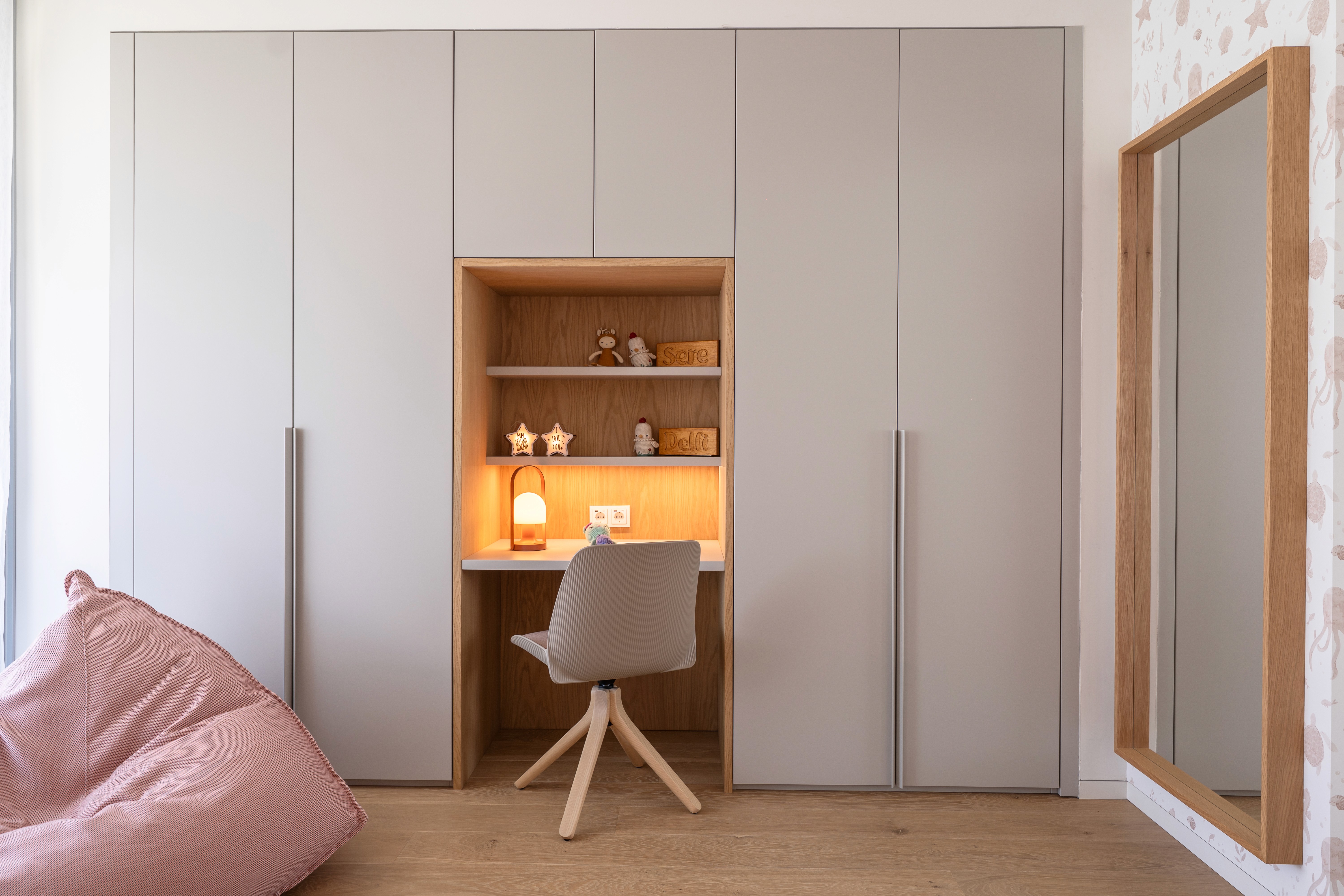 Zona de almacenamiento y estudio en habitación infantil con tonalidades rosas