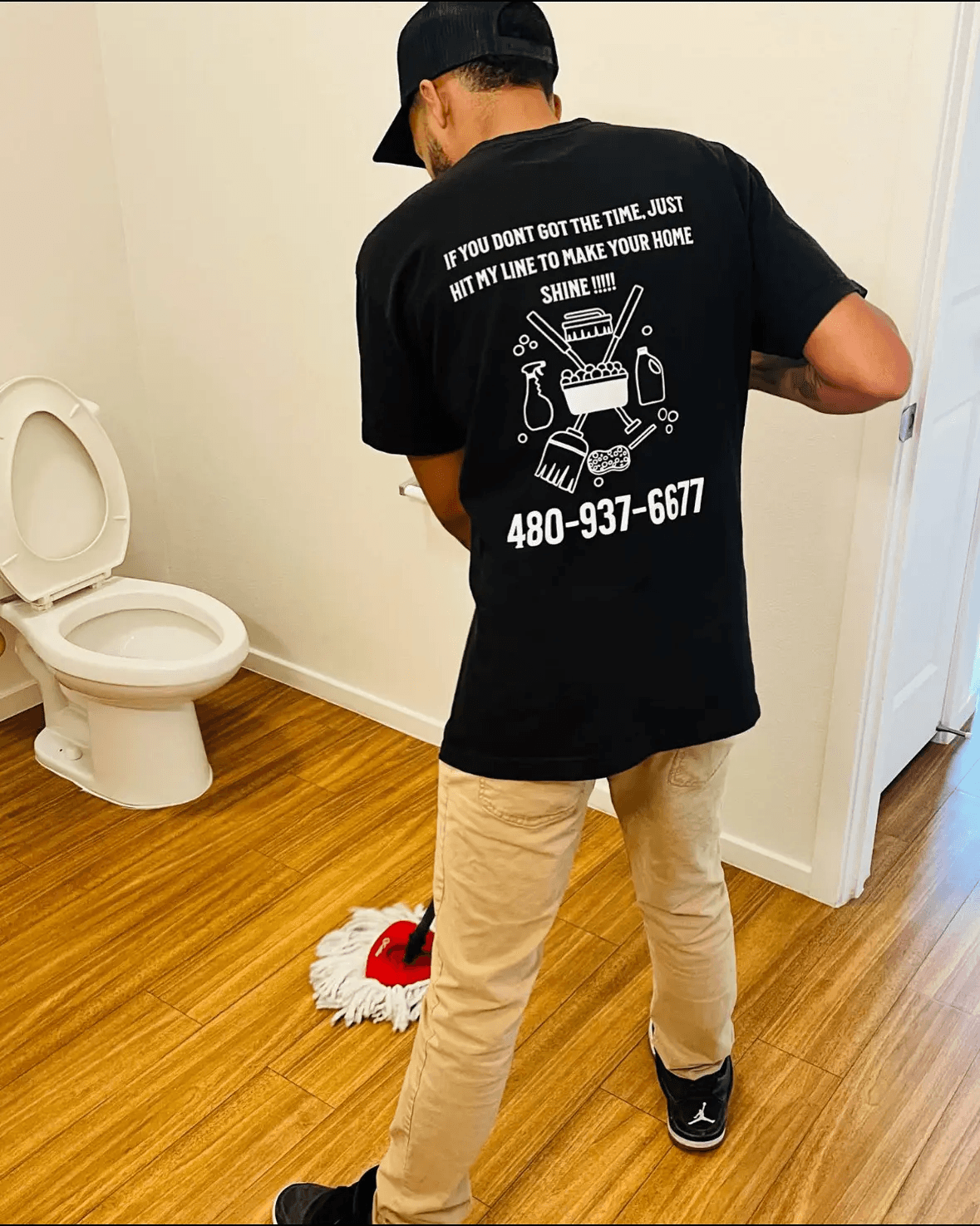 Team member mopping a floor in a clean organized restroom.