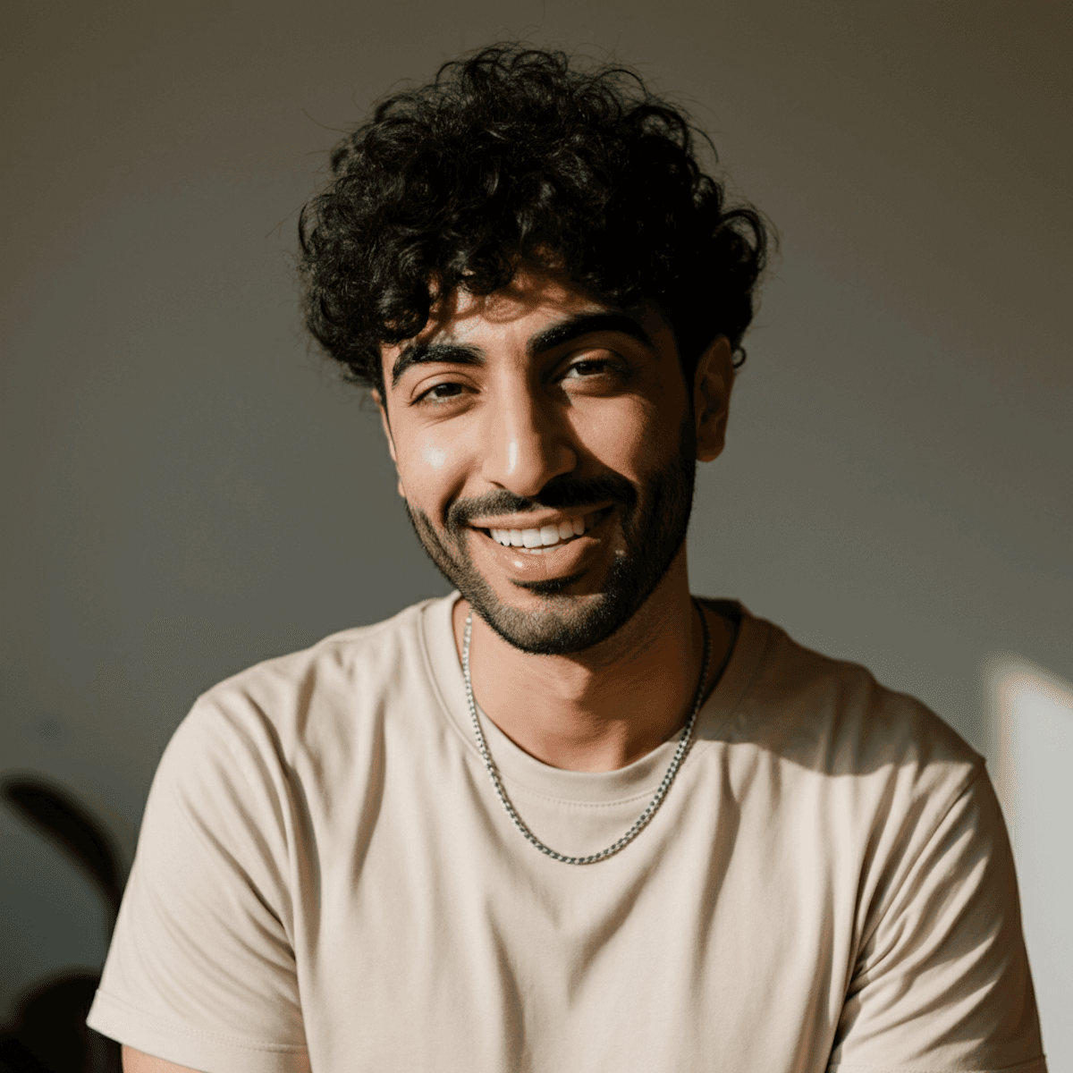 Curly haired man in casual t shirt with warm sunlight portrait