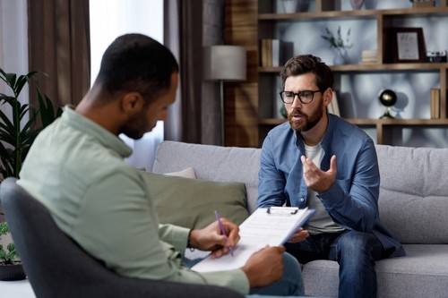 Two men sat together in counselling 