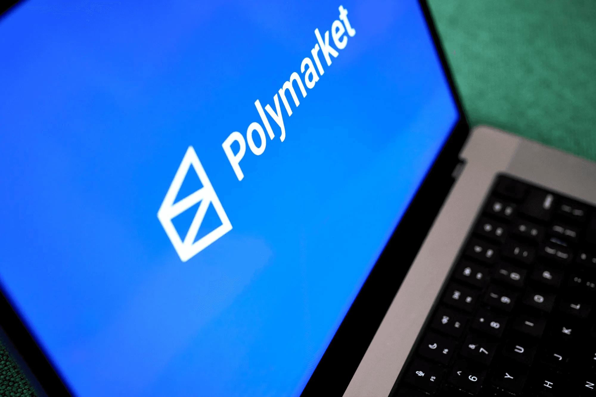 aptop screen displaying Polmarket logo - How Does Polymarket Make Money
