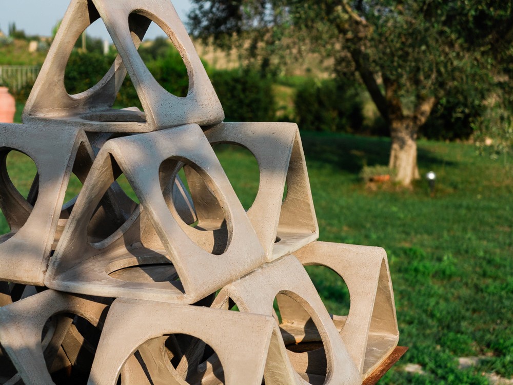 A close-up of a playful structure made of geometric shapes set against a green outdoor backdrop.