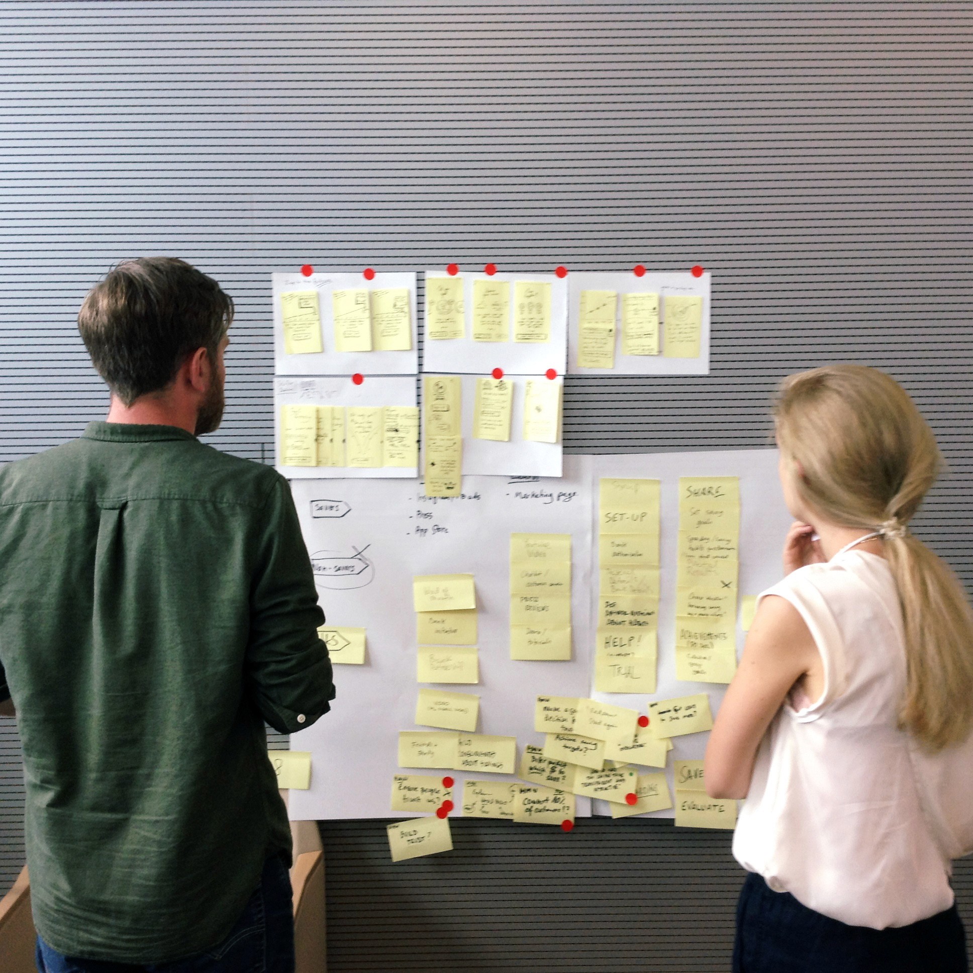 Garrett and colleague looking at post-it notes on a wall