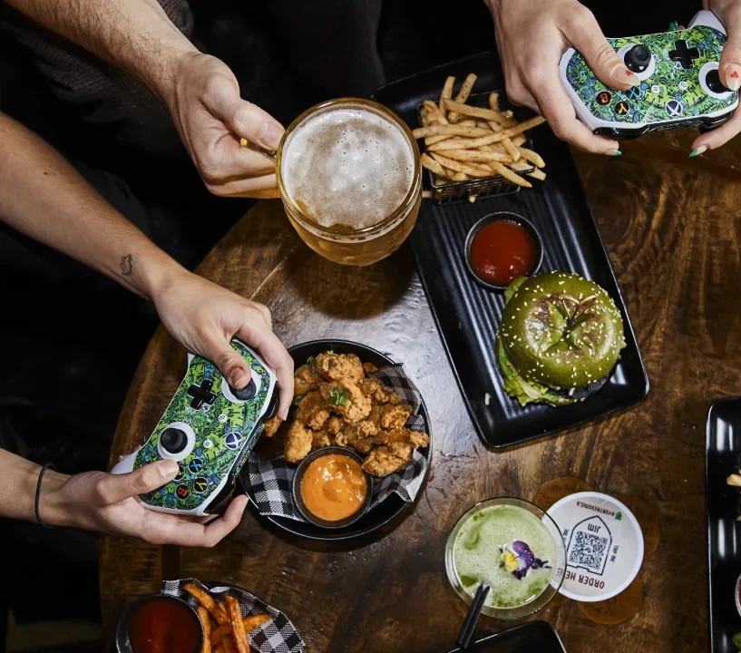 Top-down view of a group of people playing games and enjoying food and drink in the Tavern