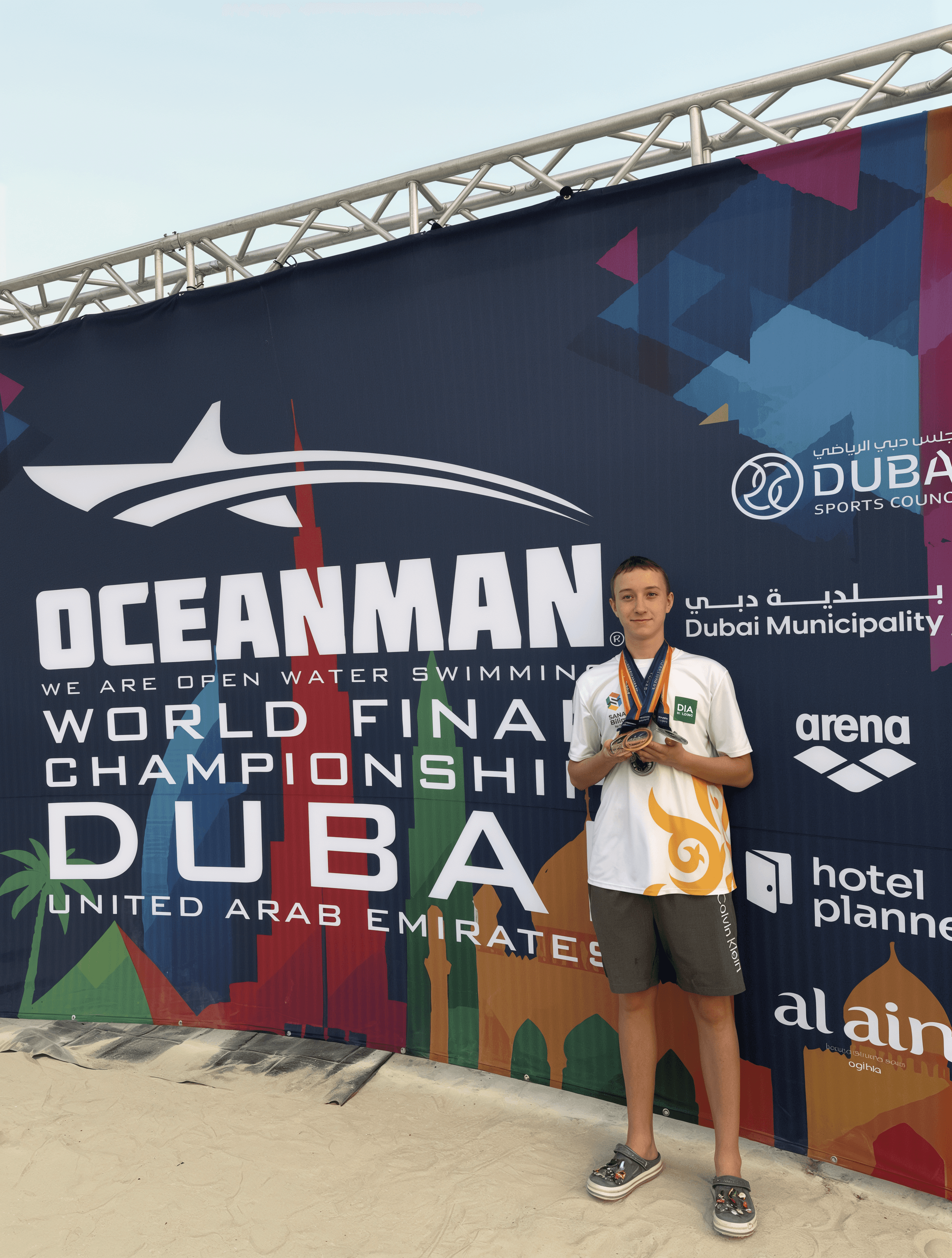 Iced coffee in a clear plastic cup with Orbit logo and swirling milk over a neutral background
