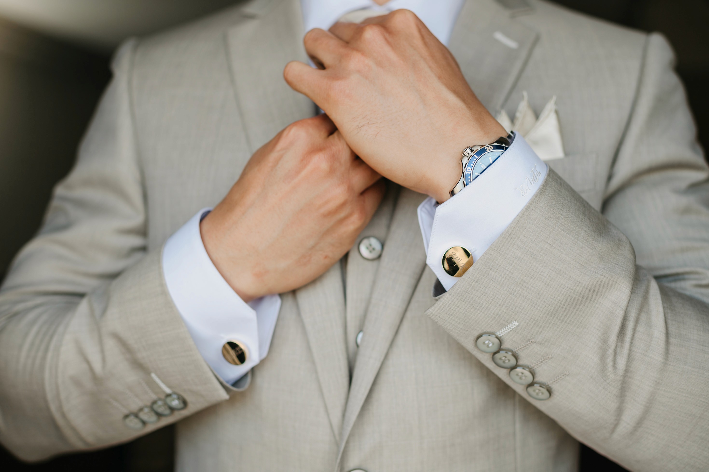 Groom adjusting tie during getting ready photos