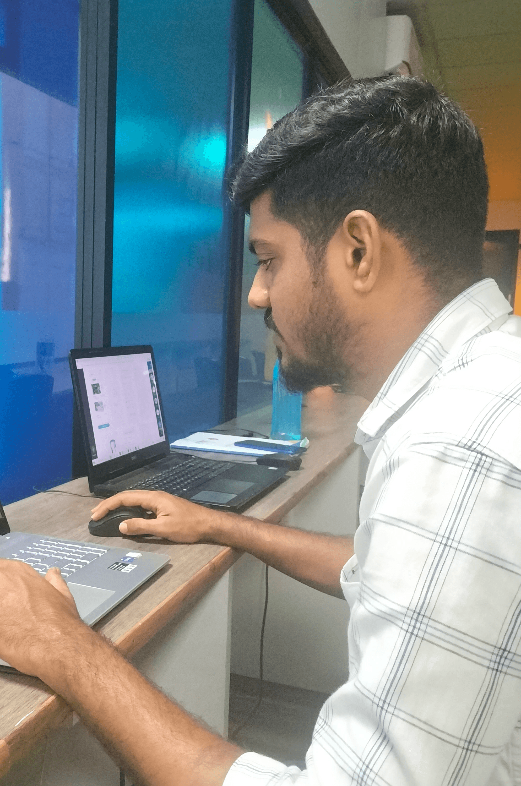 Black-and-white portrait of a bearded man wearing a hoodie and a cap, looking directly at the camera against a dark background.