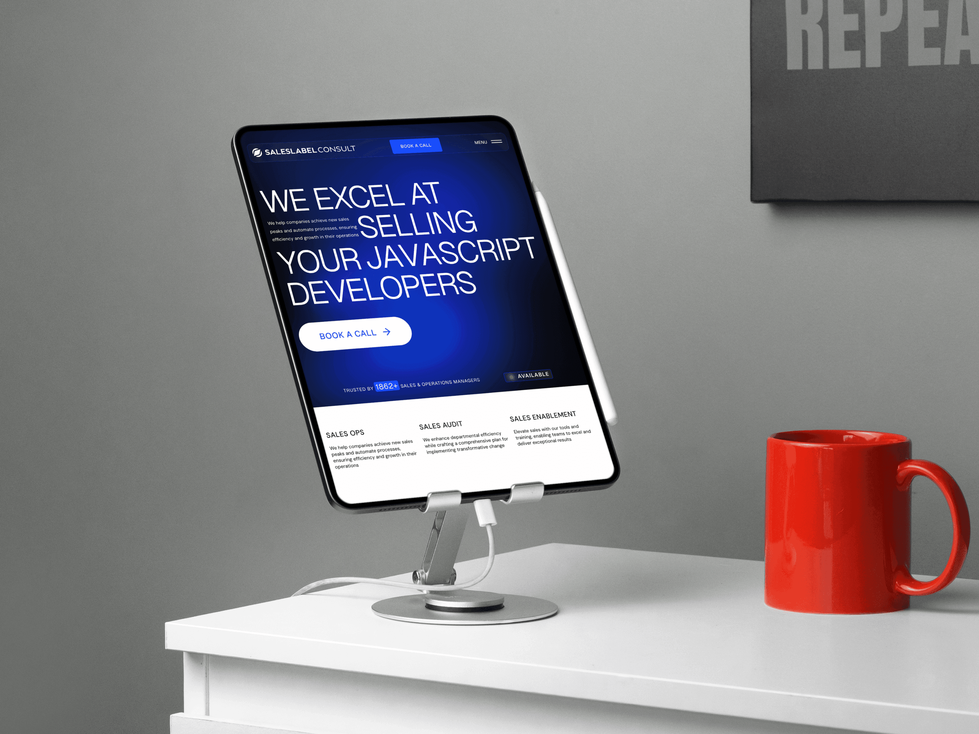 A tablet on a desk showing the mobile version of the Sales Label Consulting website, highlighting their expertise in selling JavaScript developers.