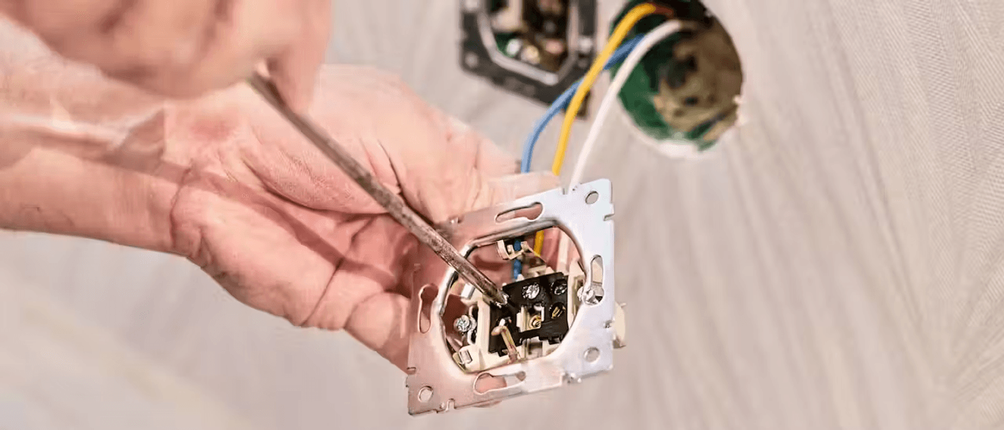 Someone using a screwdriver to install a socket.