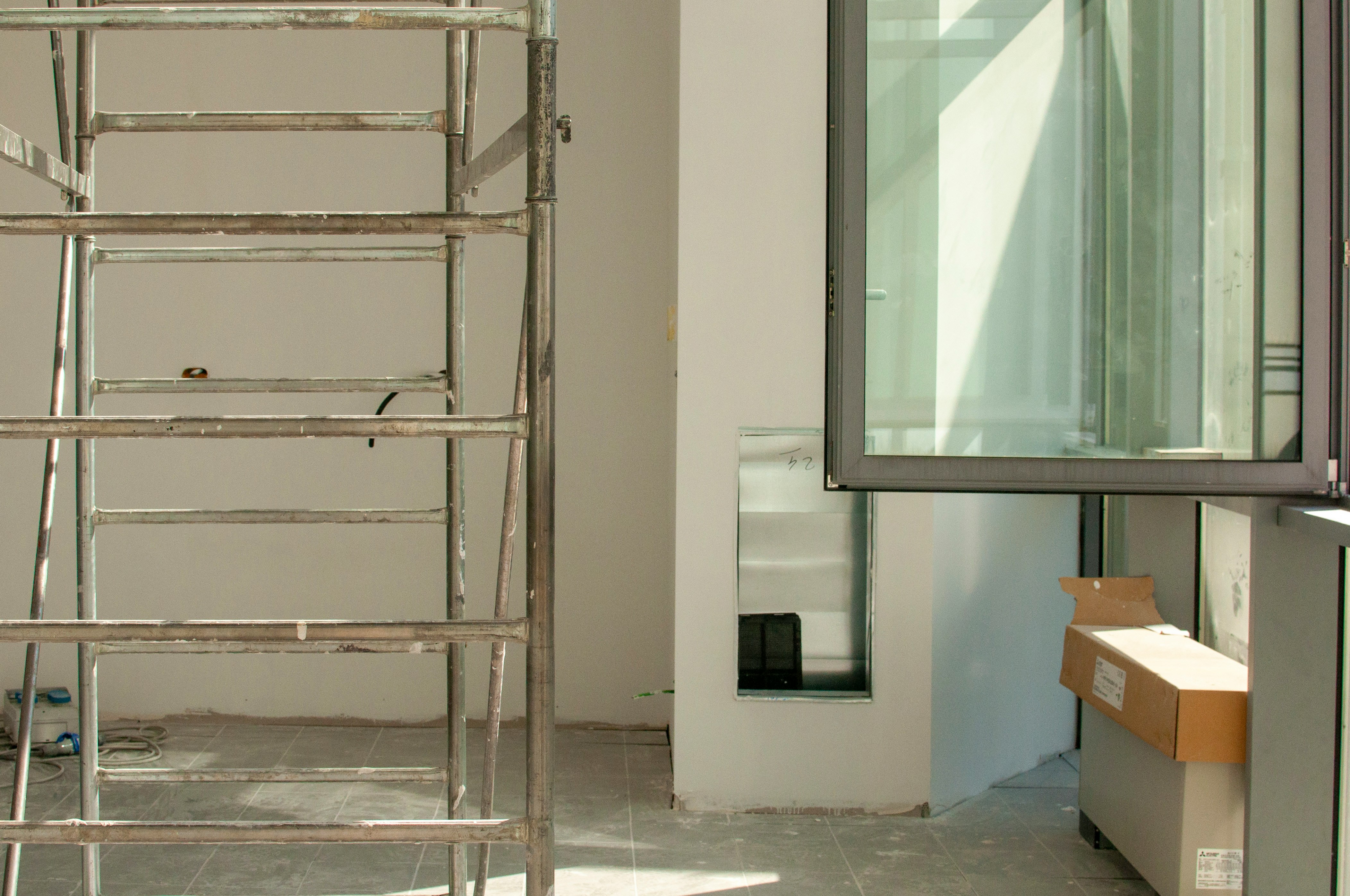 stainless steel ladder leaning on white wall