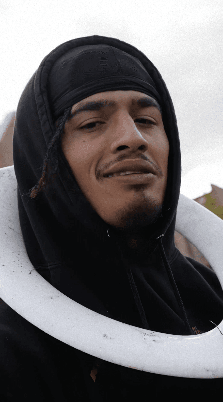 Bride in white dress walking on street, man in background