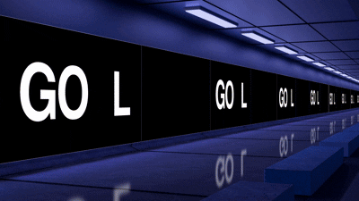 Bright digital billboards illuminate a city corner at night.