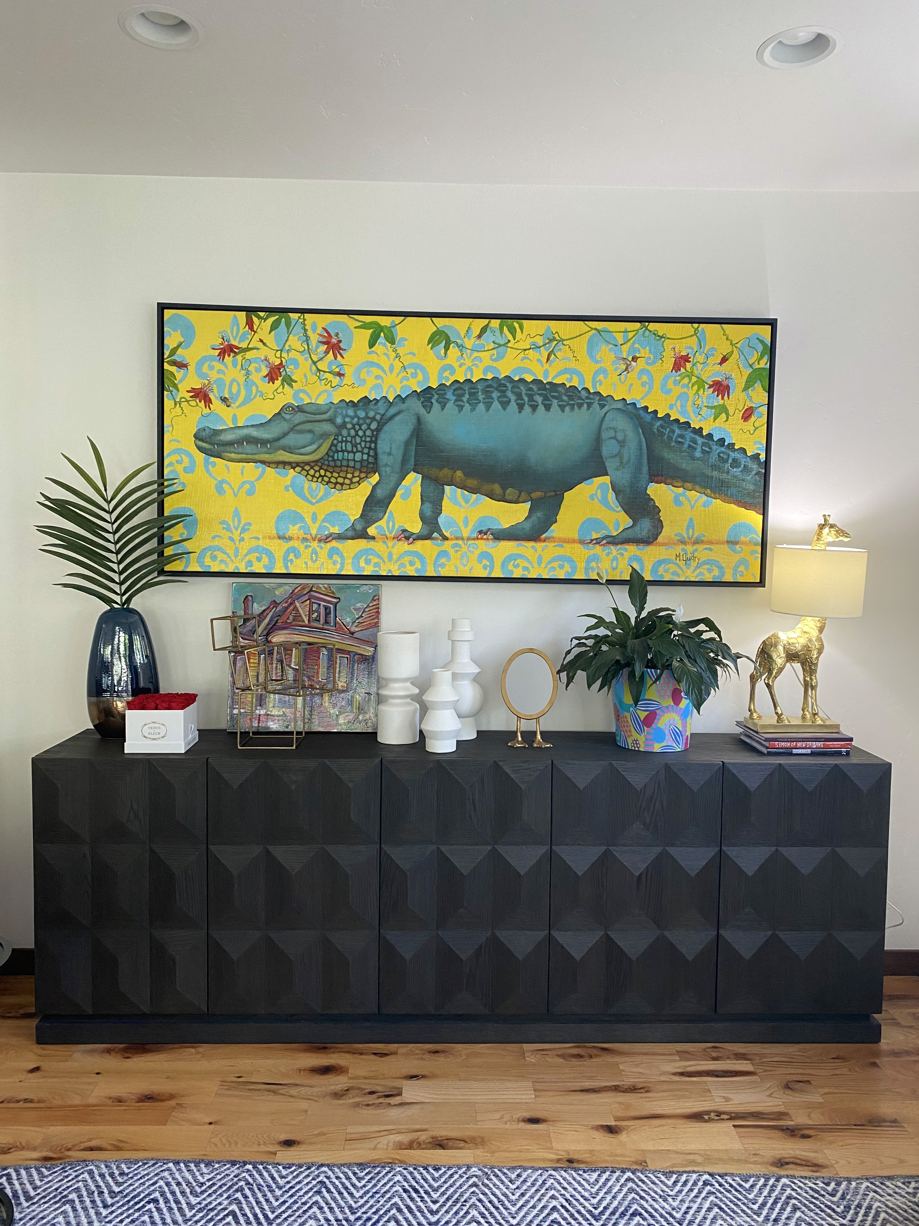 brown credenza with home decor and alligator painting