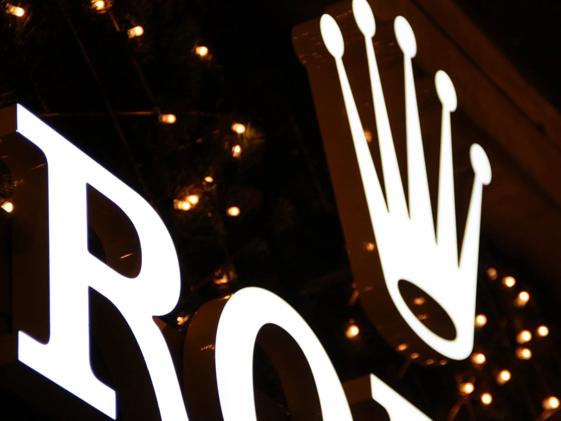 Bílé světelné logo Rolex s korunkou z akrylátového masivu MaxxLuxx, noční záběr