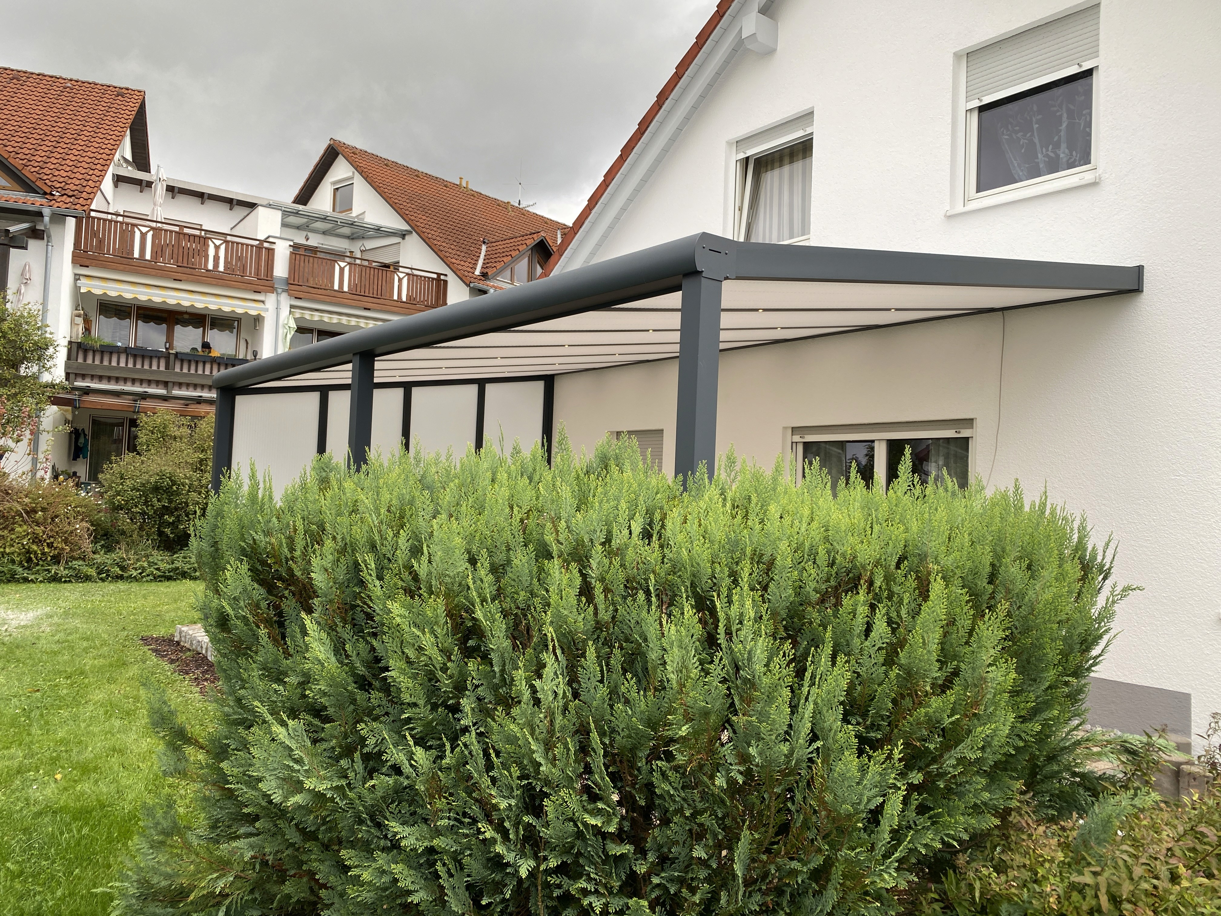 Angebaute Alu-Terrassenüberdachung mit Glasdach über der Terrasse