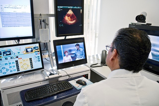 A doctor sitting in front of multiple monitors