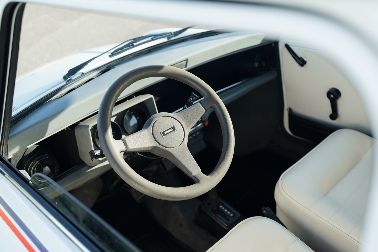 Close-up view of a car interior featuring a steering wheel and part of the dashboard and seats.