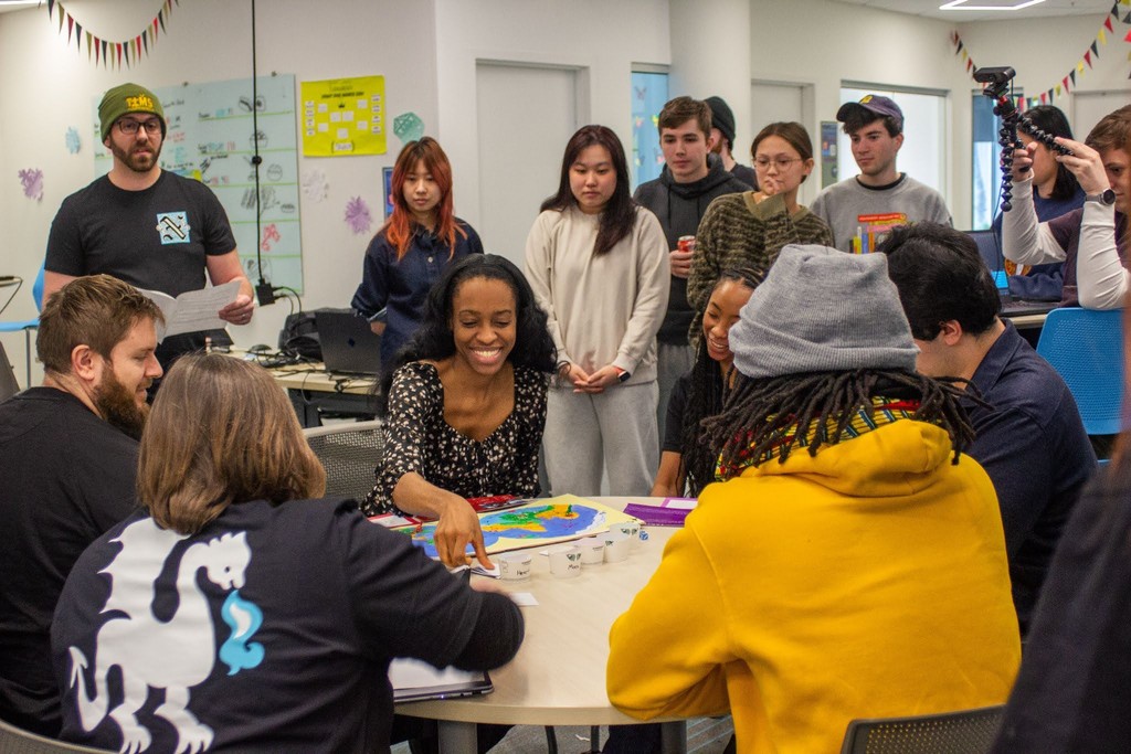 Game jam participants demonstrating their board game to a panel of judges
