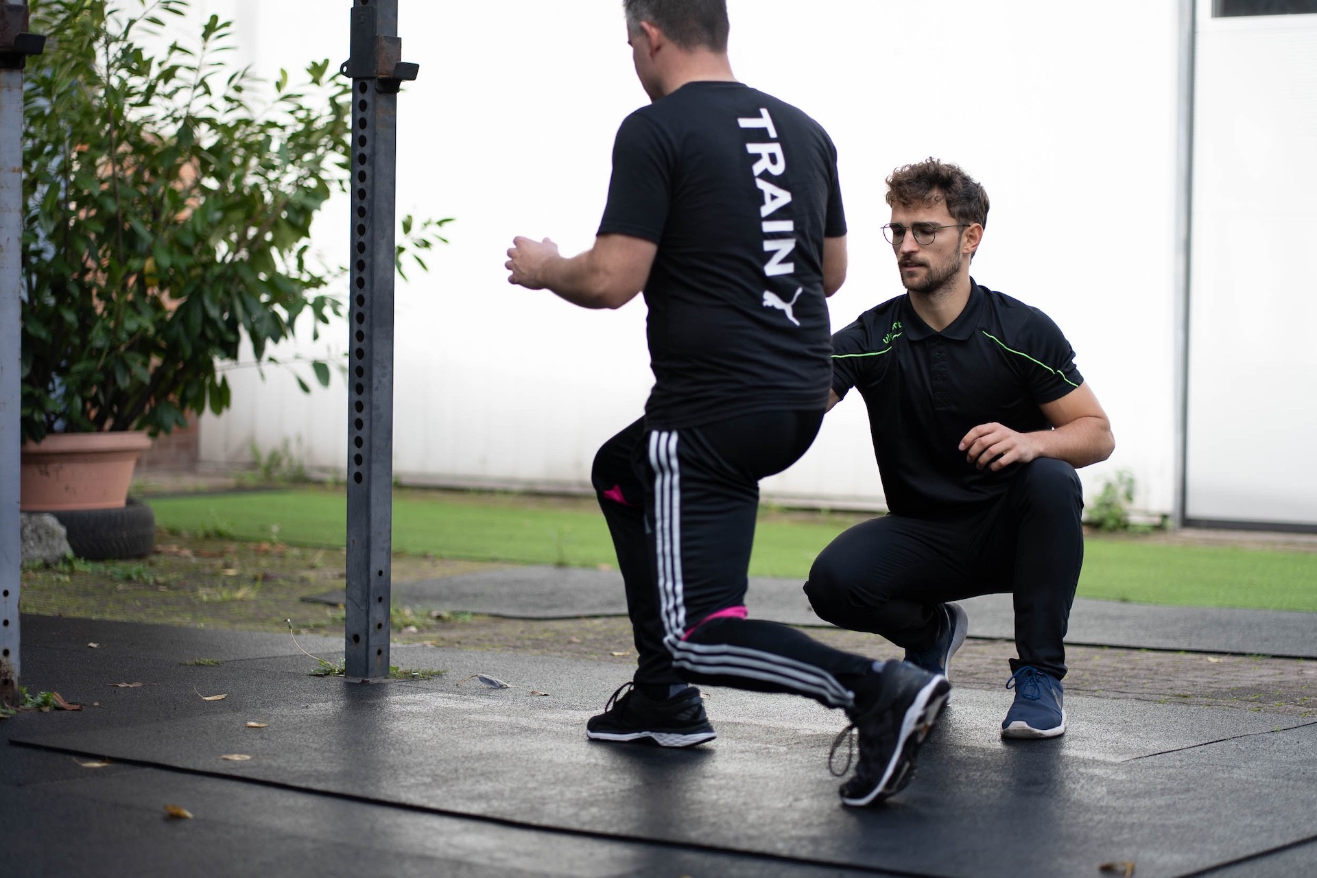 Lukas Kazimierski analysiert die Bewegungsausführung eines Klienten beim Ausfallschritt im Personal Training