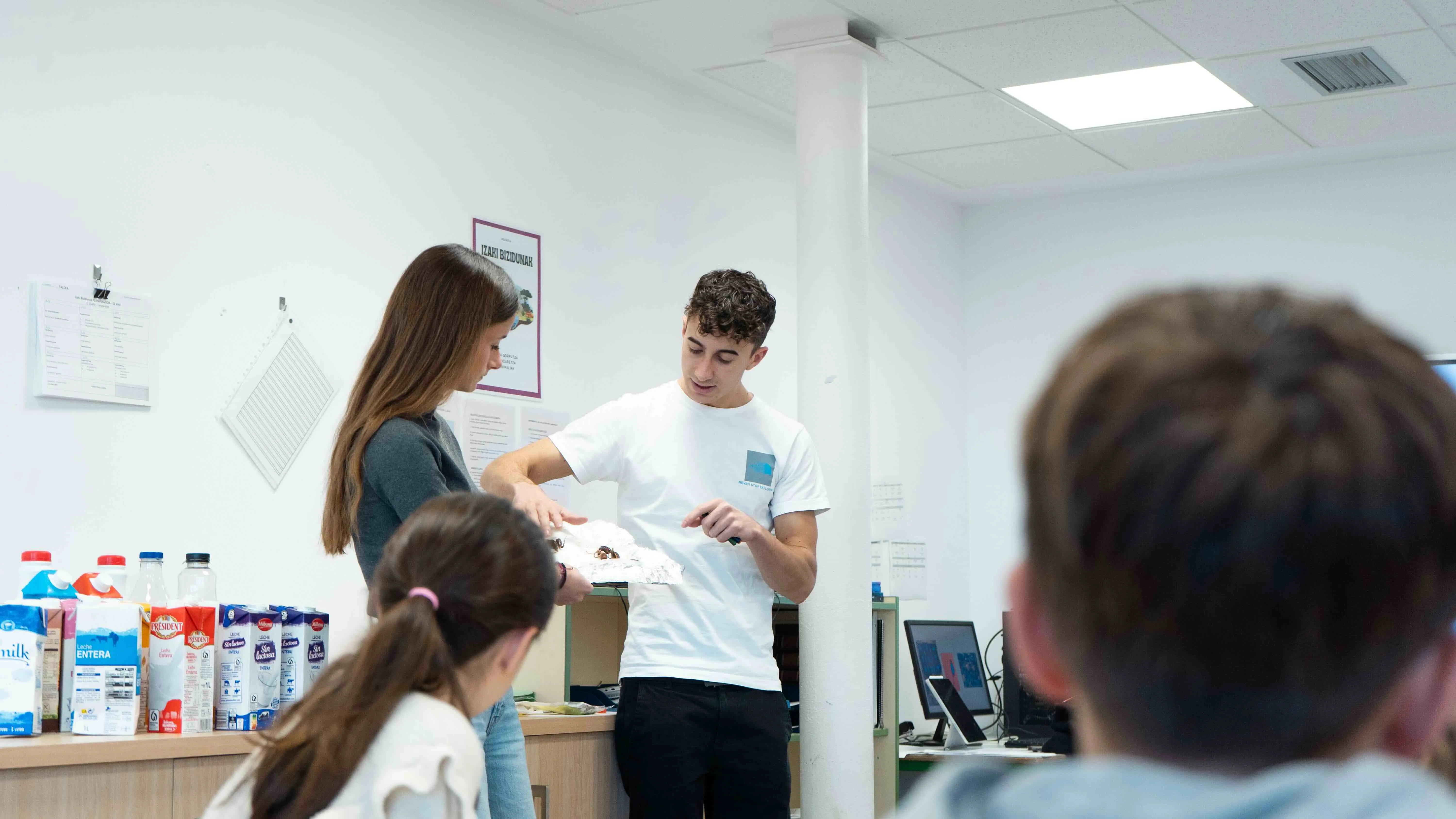 Close-up of lush, dark green leaves, some glossy and wet, against a muted background.
