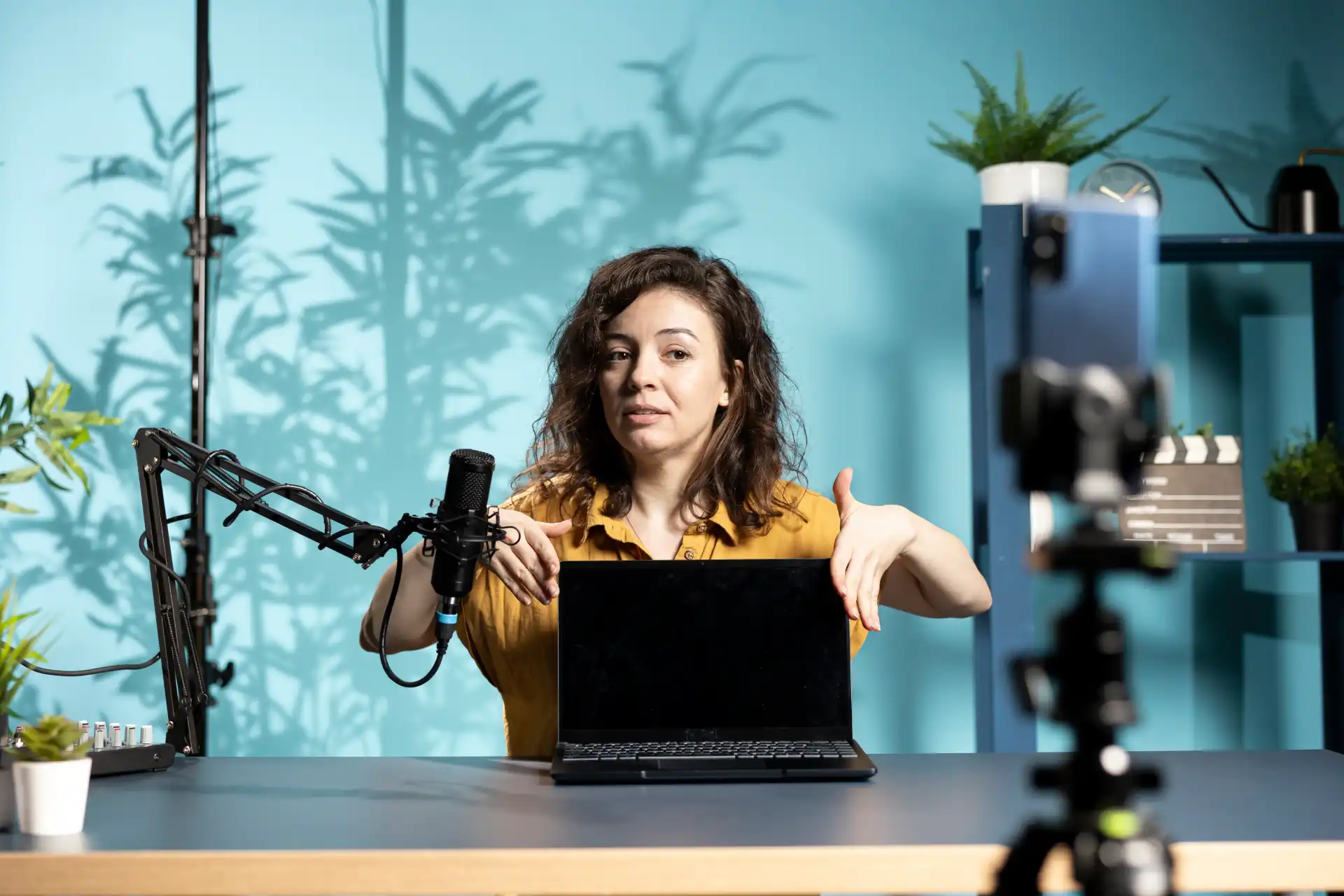 TikTok creator filming product review video for Shop affiliates using professional camera and microphone equipment at desk
