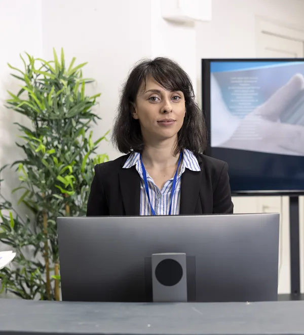 Hospital receptionist at the front desk ready to help patients with bookings and forms