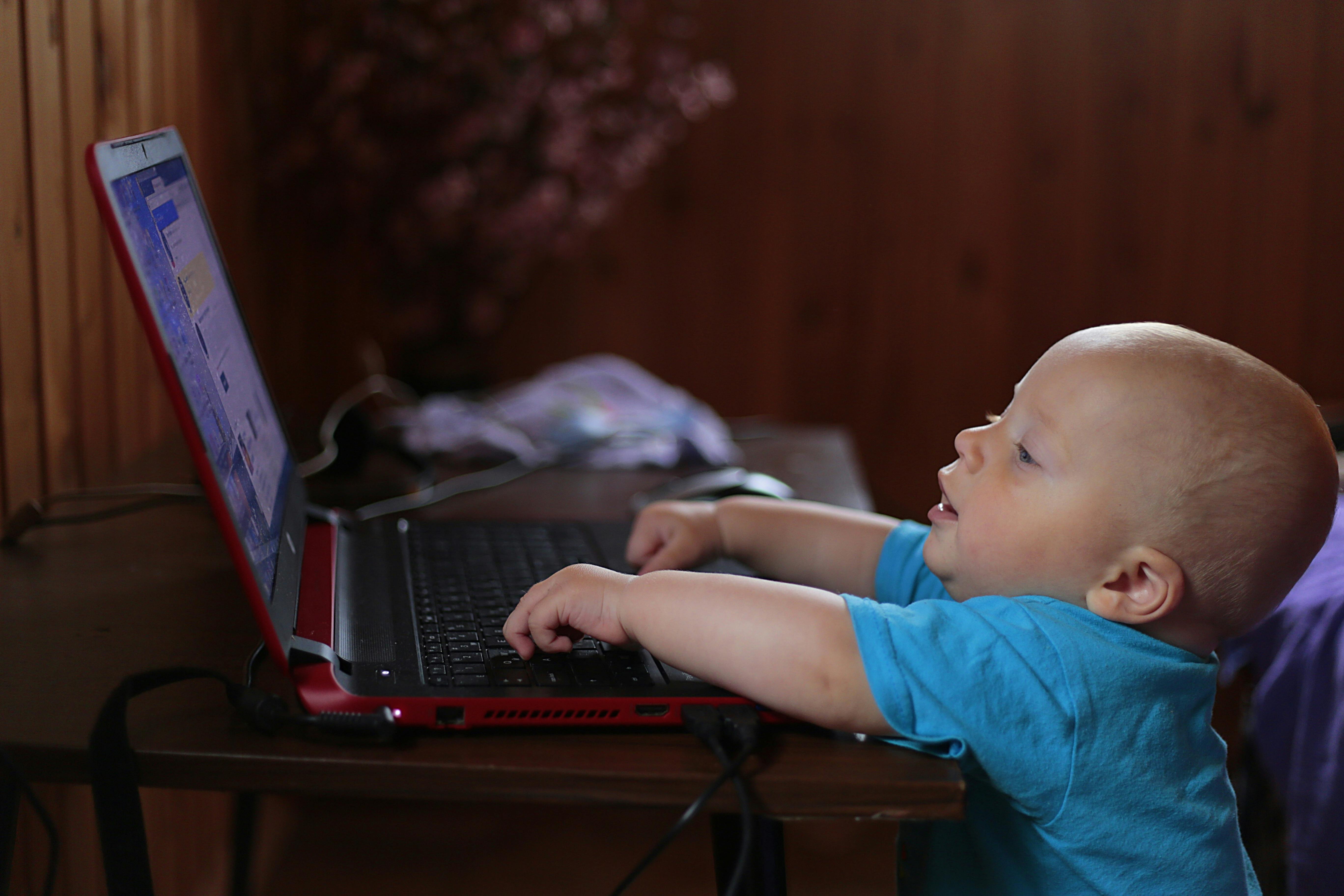 A baby uses a laptop.