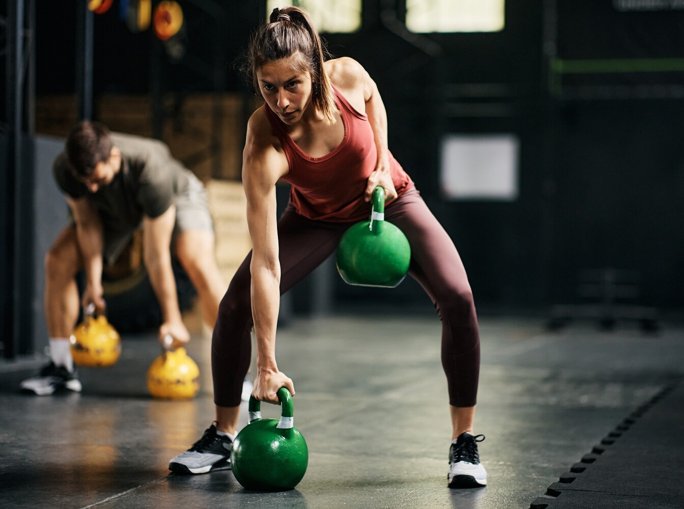 older man doing strength training exercises at the gym before using a sauna or steam room for weight loss