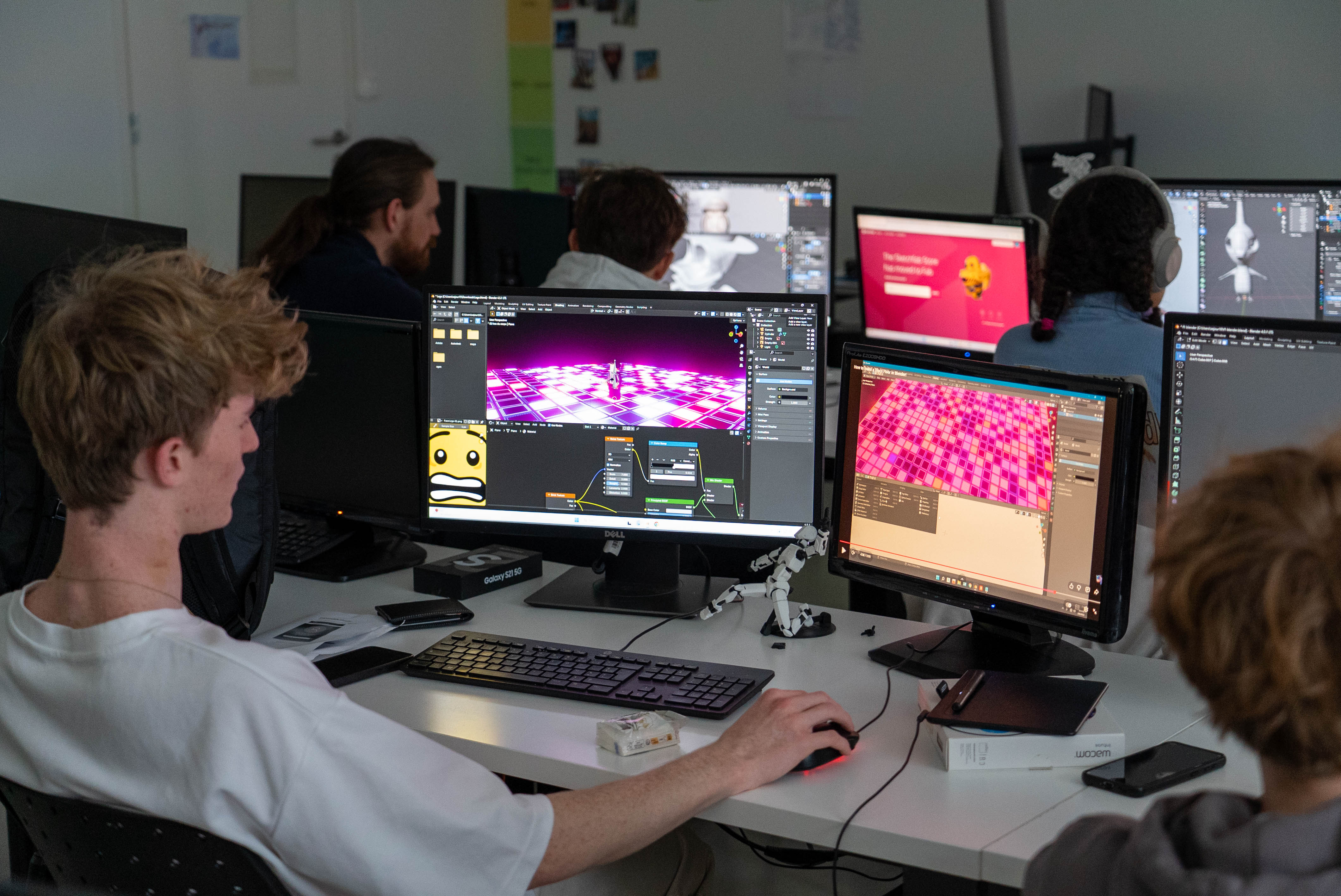 Une étudiante concentrée regarde un écran d'ordinateur affichant une animation 3D d'un personnage mignon.
