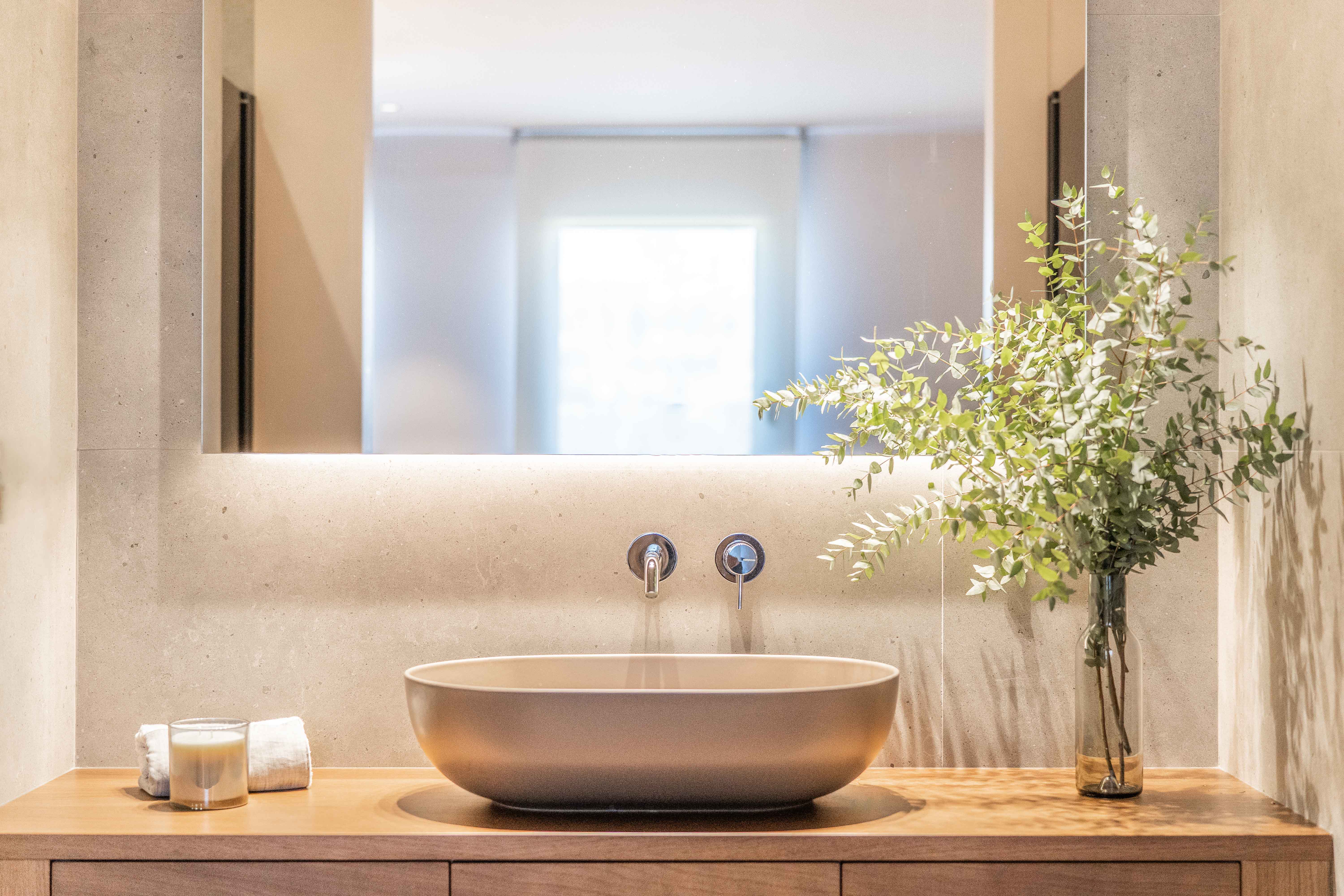 Baño en suite con mueble de madera y pila sobre encimera