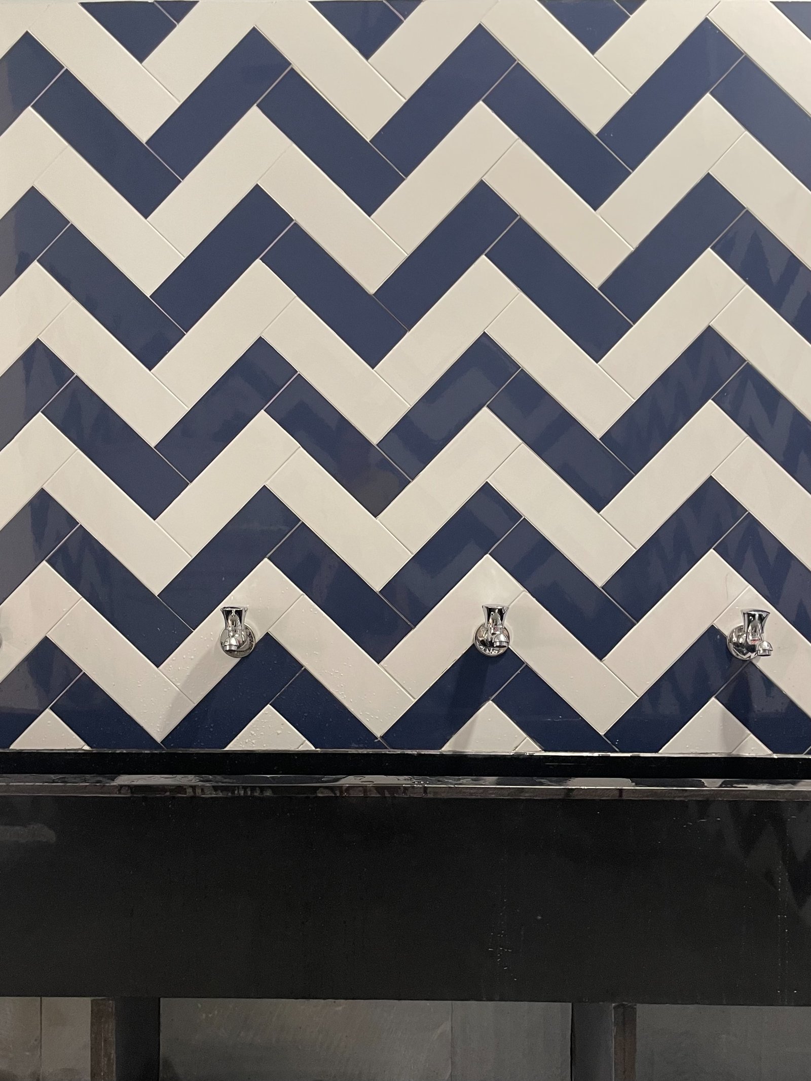 Nature-inspired preschool entrance with sculptural tree partitions and suspended green leaf ceiling panels.