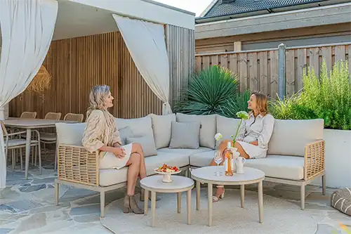 Stylish outdoor garden furniture set featuring women enjoying a relaxing moment in Ibiza.