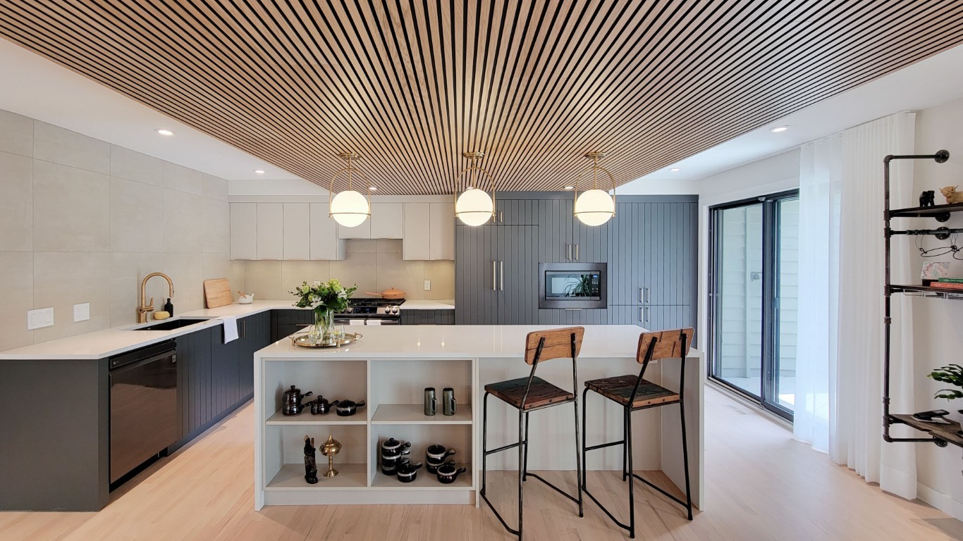Image of Modern kitchen interior with island, pendant lights, and furniture by KHD Homes design-build construction team.