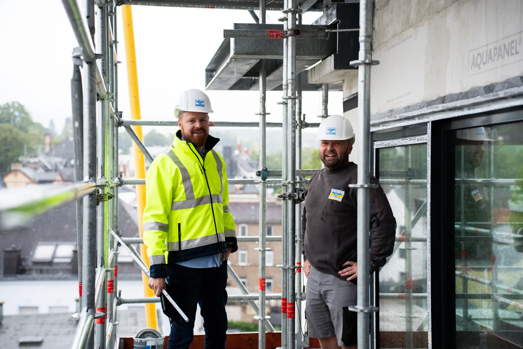 Zwei Mitarbeiter auf einem Baugerüst