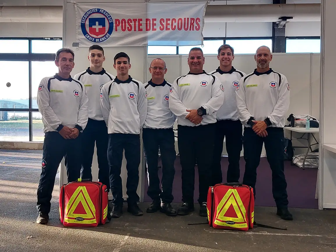 Équipe de secouristes français devant un poste de secours avec sacs d'urgence.