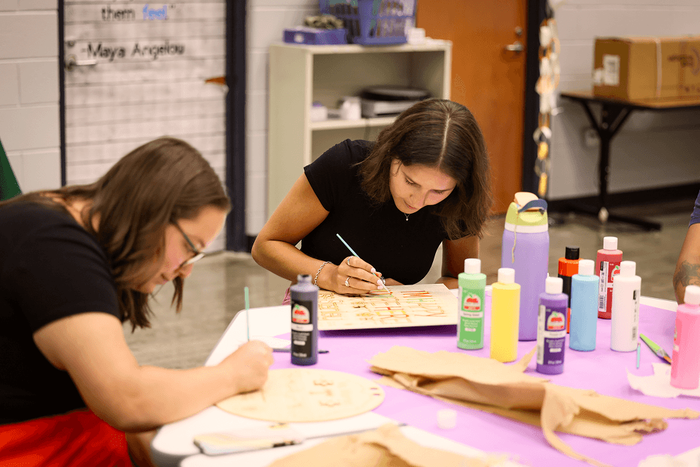 Teacher residency participant creating a classroom sign using Fab Lab tools, reflecting hands-on learning and classroom preparation.