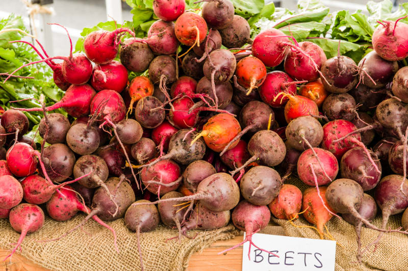 lots of raw garden beets on wood table with beets sign