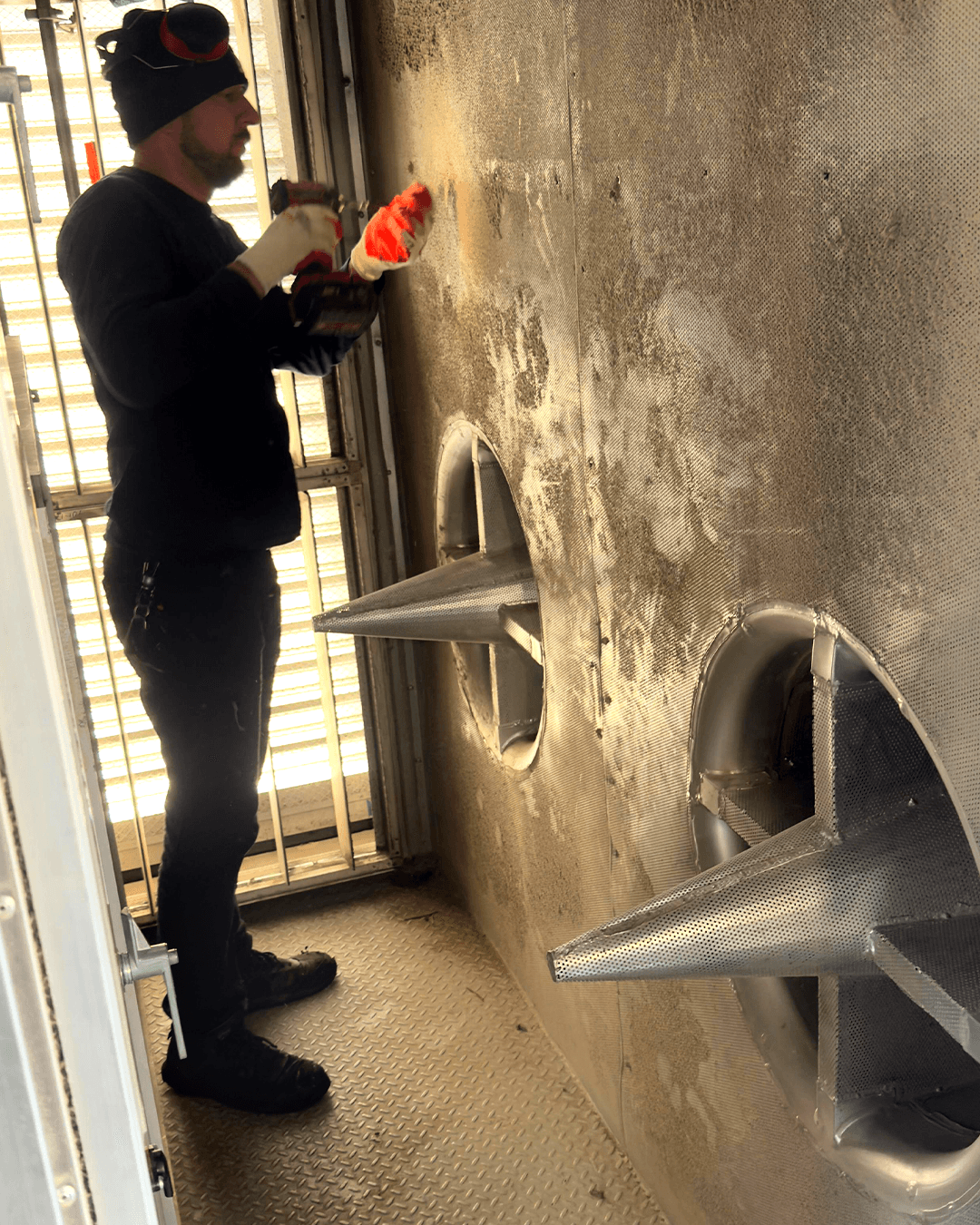 GRR Cooling Experts technician preparing to remove a legacy fan assembly inside a hospital air handling unit prior to retrofit.