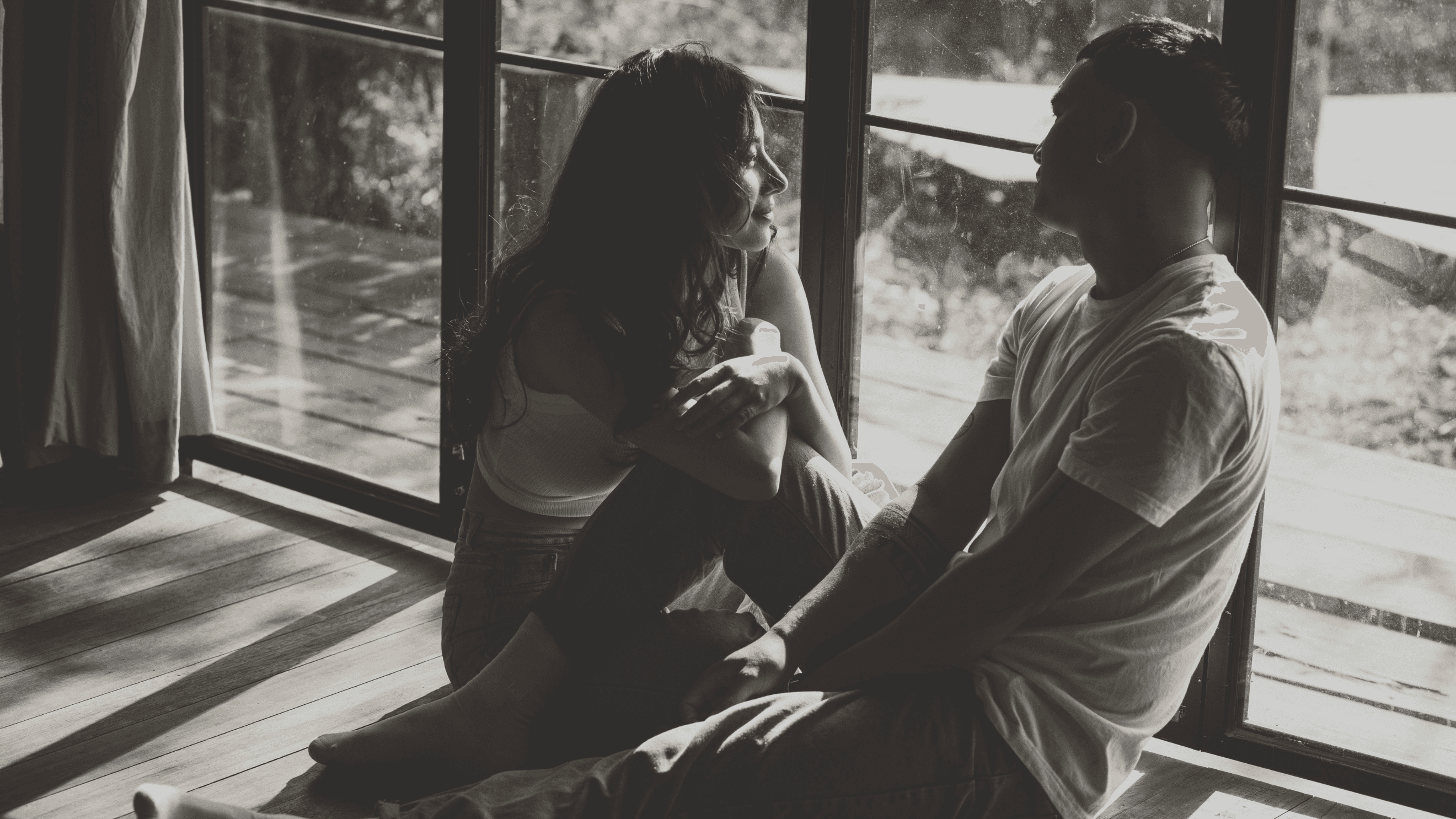 a photo of a couple sirting by the window