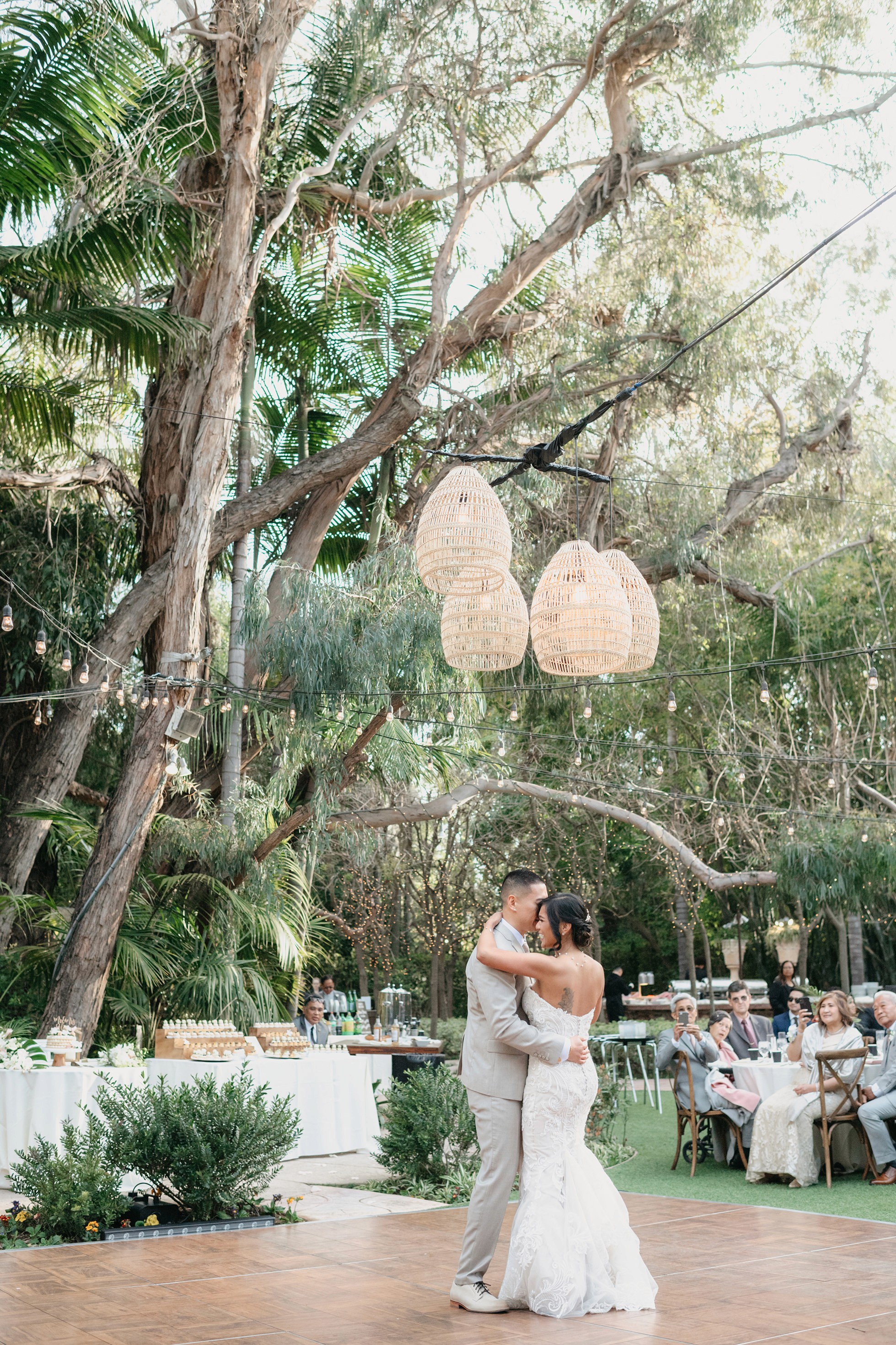 Bride and groom first dance with guests cheering