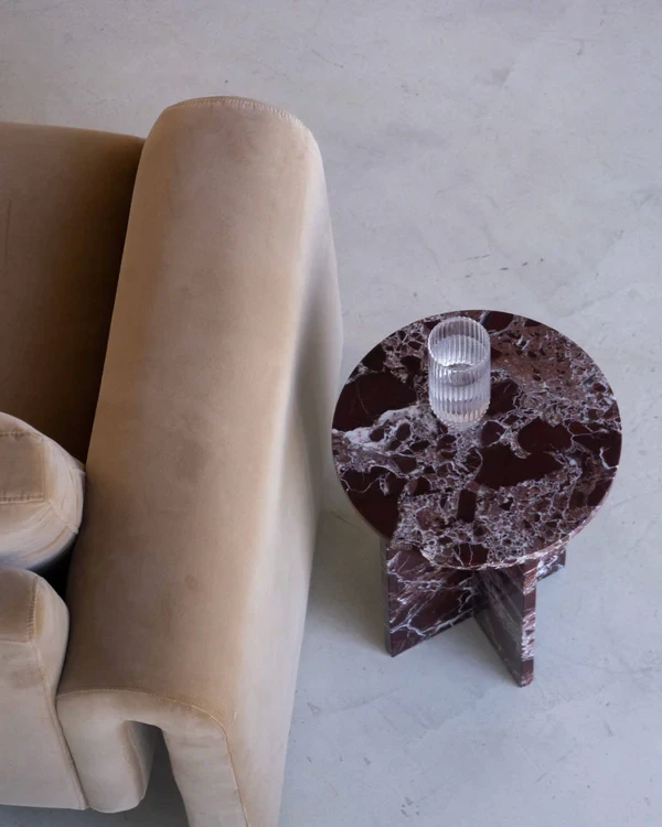 Minimalist workspace with natural stone columns, Scandinavian-style furniture, golden light, and greenery.
