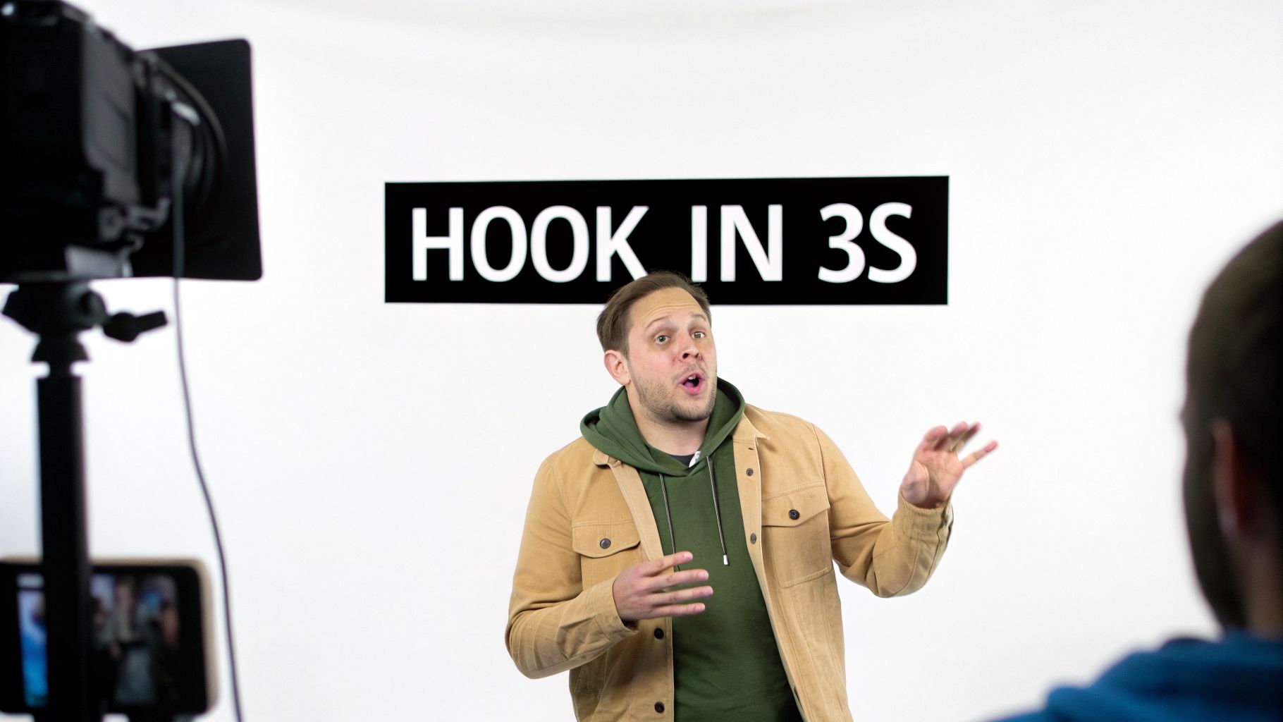 Man speaking in front of a camera on a white background with a 'HOOK IN 3S' sign.