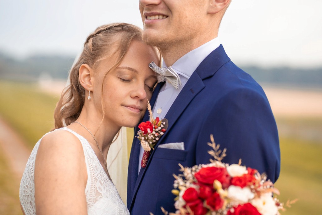 Nahaufnahme Braut lehnt an Bräutigam während Hochzeit in Rosenheim