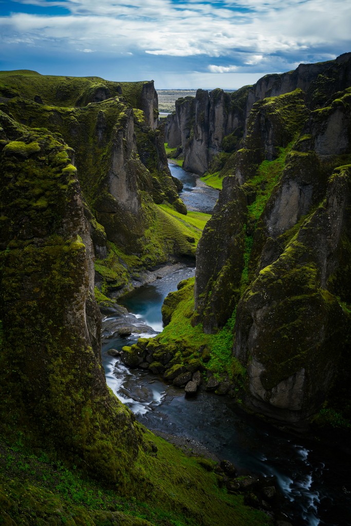 A green canyon with water flowing through